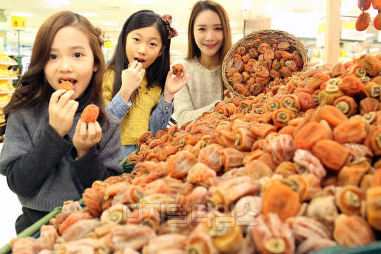 13일 오전 서울 한강로 이마트 용산점에서 모델과 아이들이 겨울철 제철 먹거리 곶감을 선보이고 있다. 이마트는 14일부터 청정지역인 상주 유식산 중턱에서 건조한 경상북도 상주산 곶감을 18개 골라 담아 9800원에 판매한다. 이마트 제공